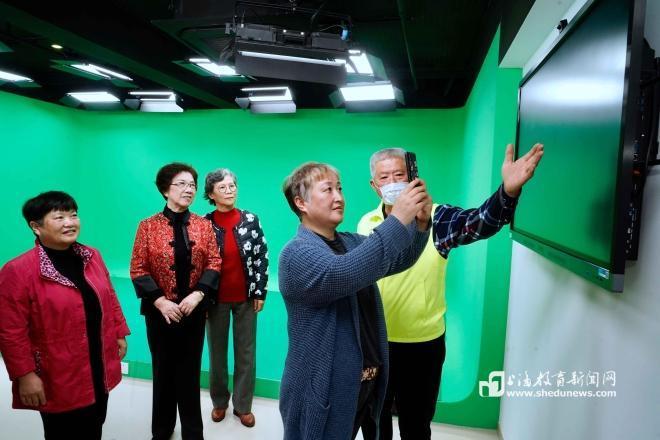 上海老年大学学员在“快乐岛”下载刚刚拍摄的视频（朱水苗 摄）.jpg