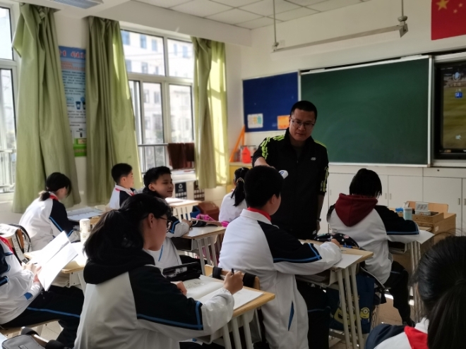 担任了9年班主任的宝山区高境一中体育老师李炜为学生测量体温。 受访者供图