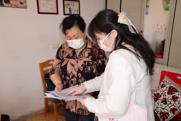  社工上门为孟阿姨讲解“线上课堂”课程表及注意事项。
